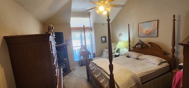 Bedroom with baseboards, ceiling fan, light carpet