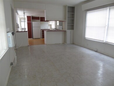 Kitchen featuring healthy amount of natural light, freestanding refrigerator, open shelves, and dark countertops