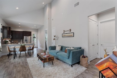 Living room with light wood finished floors, high