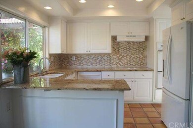 Cheerful white kitchen cabinetry and solid granite