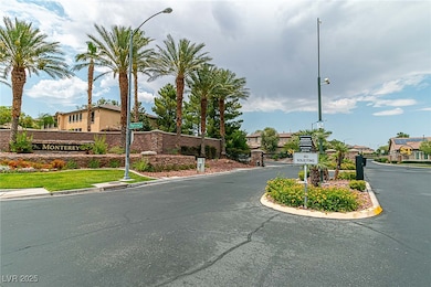 View of asphalt road featuring a gated entry, street lighting, curbs, and a residential view