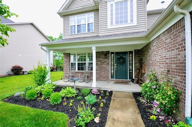 Covered front porch and nice, colorful landscaping.