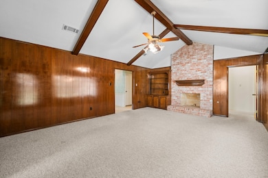 The stylish living room offers cathedral ceilings, and architectural details such as the brick fireplace.  Leave the brick natural as is, or paint for a more modern feel.