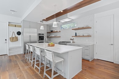 Kitchen featuring open shelves, gray cabinets, de