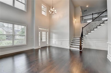 Entryway with an inviting chandelier, wainscoting,
