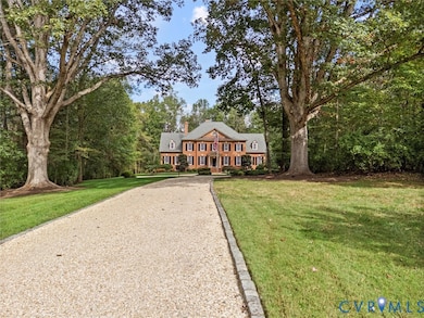 View of front of house with a chimney, a front lawn, and gravel driveway