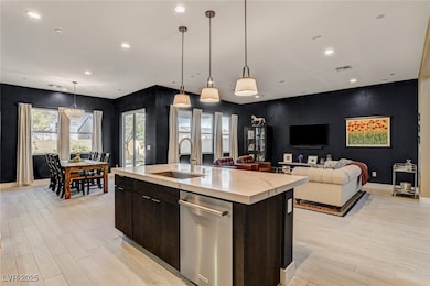 Kitchen featuring a kitchen island with sink, ligh