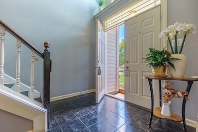 Entrance foyer with stairway and dark tile patterned floors