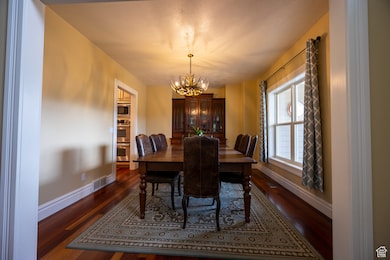 Dining space with dark wood finished floors and a chandelier