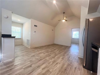 Open floor plan living room and kitchen with cathedral ceiling
