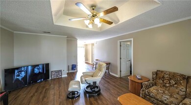 Living area with crown molding, visible vents, a c