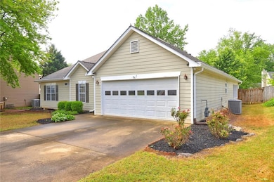 Ranch-style home featuring concrete driveway, a ga