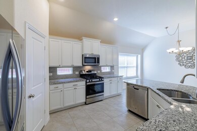 Kitchen featuring white cabinets, lofted ceiling,