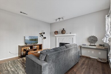 Living room with rail lighting, a fireplace, and d