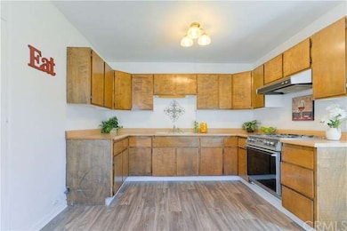 New designer flooring, rich wood cabinetry, a four burner Kenmore stove with Stainless Steel Vented hood. A lighted ceiling fan in the informal dining area.