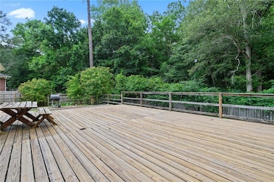 Wooden deck featuring grilling area and outdoor dining area