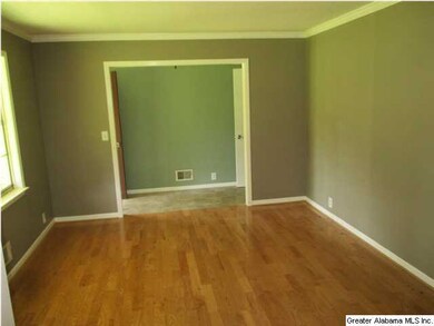 Living room has hardwood floor and crown moulding.