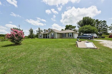 View of front of house with a garage, driveway, and a front yard