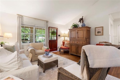Living room featuring wood finished floors and lofted ceiling