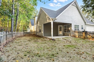 Rear view of house with a patio area, roof with shingles, and a fenced backyard