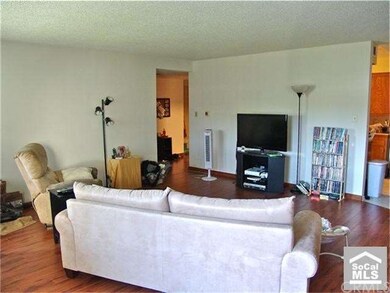 living room features laminate wood flooring...