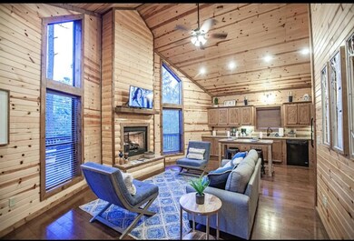 Living room with wooden walls, high vaulted ceiling, hardwood / wood-style floors, wood ceiling, and plenty of natural light