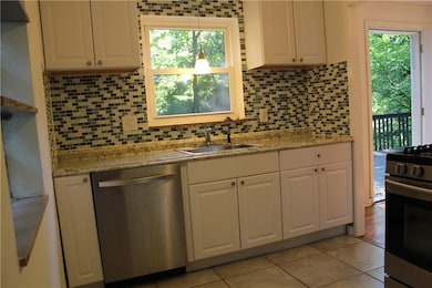 The kitchen is light and bright with glass mosaic 