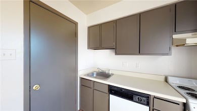 Kitchen featuring under cabinet range hood, gray c