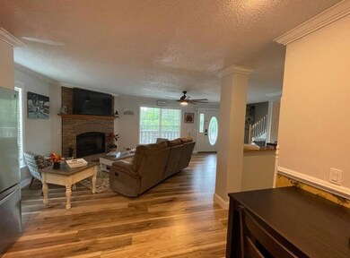 Living room with crown molding, light wood-type fl