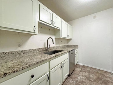 Kitchen featuring baseboards, a sink, dishwasher, 