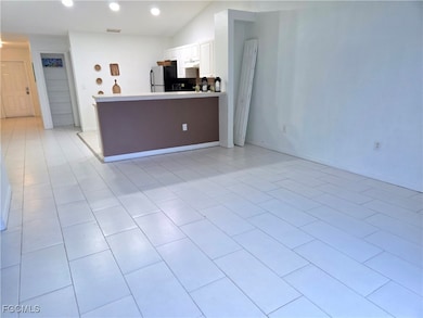 Living area with light tile patterned flooring and recessed lighting