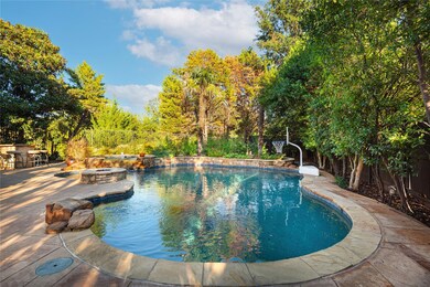 Pool with expansive deck and lush landscaping