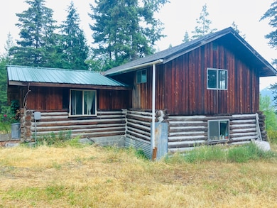 View of front facade with log exterior and a metal roof