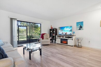 Living area featuring light wood-style flooring and a glass covered fireplace