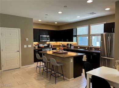 Kitchen with stainless steel appliances, dark cabi