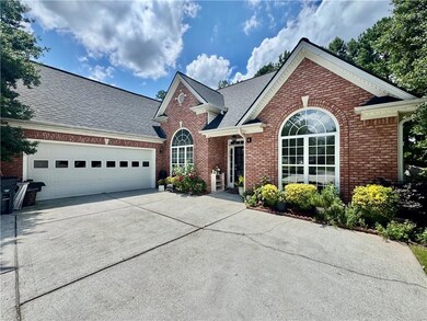 Traditional-style house with brick siding, driveway, a garage, and a shingled roof