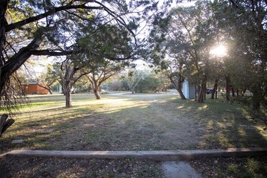 Yard to the house from road. Ample room for an addition to the original home or space for a new lake home.