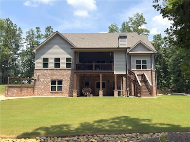 Back of house featuring a patio, a yard, brick siding, a shingled roof, and stairs