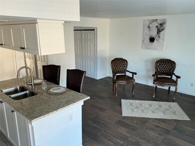Kitchen with light stone counters and white cabinets