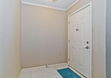 Doorway with a textured ceiling, ornamental moldin