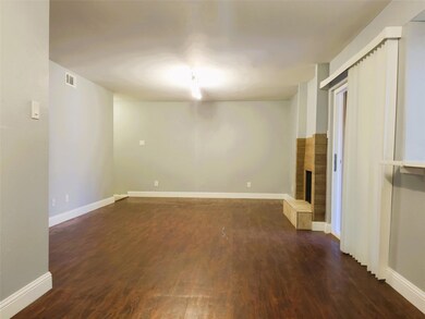 Unfurnished room with a tiled fireplace and dark w