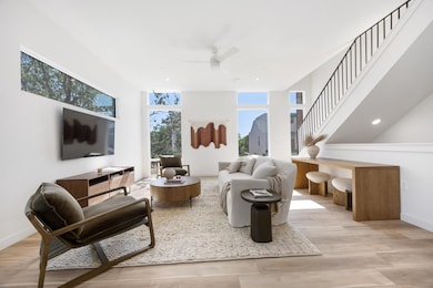 Living room with stairs, light wood-type flooring, ceiling fan, and recessed lighting