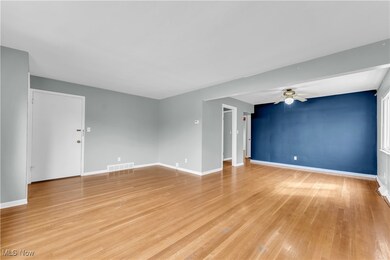 Unfurnished living room with visible vents, baseboards, a ceiling fan, and light wood-style flooring