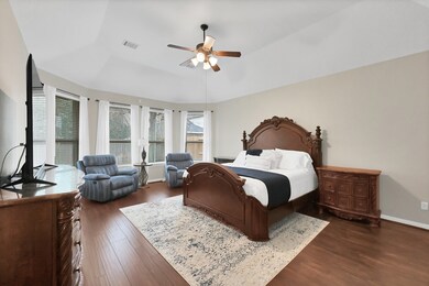 What a wonderful place to come home to, this stunning primary suite greets you with warm custom paint, high ceiling, ceiling fan with lighting, large windows with blinds allowing in natural light brightening up this spacious primary bedroom, with extra space for a seating area.