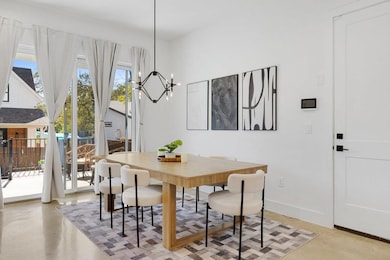 Dining area with finished concrete flooring and a chandelier
