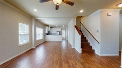 Unfurnished living room with crown molding, dark w