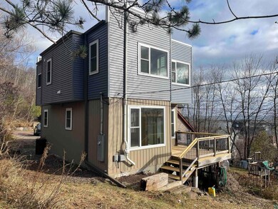 View of side of home featuring a wooden deck