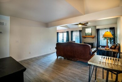 Living room with a large fireplace, tile floors, and ceiling fan