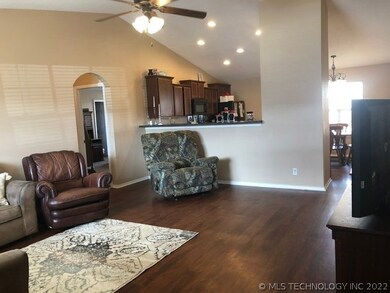Open living room with vaulted ceiling and arched d