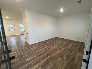 Empty room with dark wood-style floors and recessed lighting